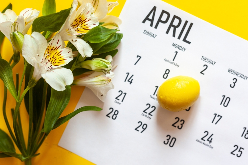 physical calendar for April with flowers on the left and a mini chocolate egg set on top